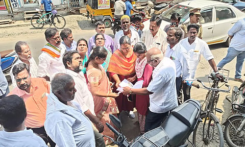 சாலை விரிவாக்க பணிக்காக அளவீடு செய்யும் பணியை கோட்ட ெபாறியாளர் ஆய்வு செய்த காட்சி.