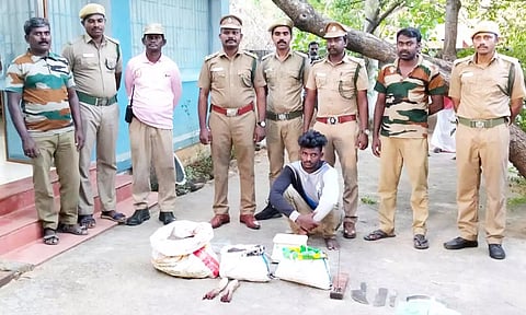 கைதான காளிராஜையும், அவரை பிடித்த வனத்துறையினரையும் படத்தில் காணலாம்.