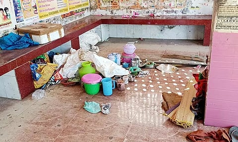 பயணிகள் நிழற்கூடத்தில் மூதாட்டி வைத்திருக்கும் வீட்டு உபயோக பொருட்கள்.