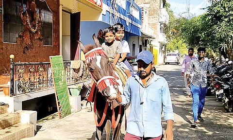 மாணவர்களை பள்ளிக்கு குதிரையில் அழைத்து வந்த தந்தை.