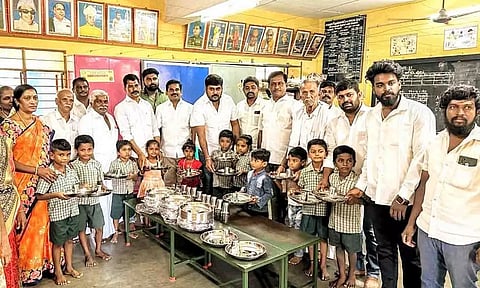 பள்ளி குழந்தைகளுக்கு சாப்பிடும் தட்டு, டம்ளர்கள் வழங்கப்பட்ட காட்சி.