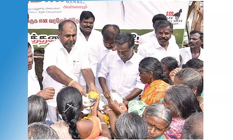 பொதுமக்களுக்கு முன்னாள் அமைச்சர் ஆர்.பி.உதயகுமார் இனிப்பு வழங்கிய காட்சி. அருகில் ஜெயலலிதா பேரவை மாநில துணைச் செயலாளர் வெற்றிவேல் உள்ளிட்ட பலர் உள்ளனர்.