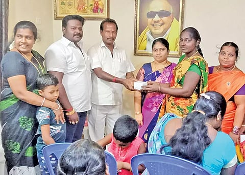 தி.மு.க.மகளிர் அணி நிர்வாகிக்கு கைக்கடிகாரம் வழங்கிய காட்சி. 