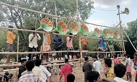 உசிலம்பட்டி அருகே நடைபெற்ற இசைப்போட்டியை முன்னிட்டு கூம்பு வடிவ ஒலிபெருக்கிகள் கட்டப்பட்டுள்ள காட்சி. 