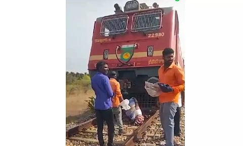 என்ஜினில் சிக்கிய உடலை ரெயில்வே ஊழியர்கள் மீட்ட காட்சி.