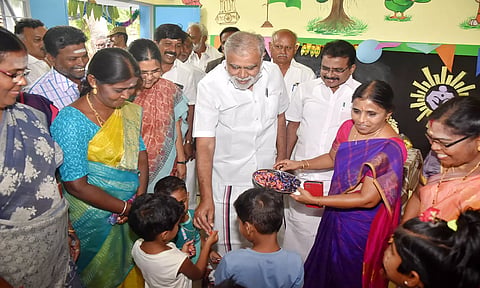 நீலமலைக்கோட்டை ஊராட்சி கரியகவுண்டன்பட்டியில் புதிய அங்கன்வாடி கட்டிடத்தை திறந்து குழந்தைகளுக்கு அமைச்சர் இ.பெரியசாமி இனிப்பு வழங்கினார். அருகில் கலெக்டர் பூங்கொடி உள்பட அலுவலர்கள் உள்ளனர்.