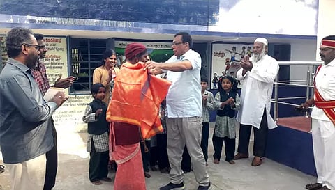முண்டகம்பாடி ஊராட்சி ஒன்றிய தொடக்கப்பள்ளி சமையலர் சோனியாவிற்கு கலெக்டர் கார்மேகம் சால்வை அணிவித்து பாராட்டு தெரிவித்த காட்சி. 