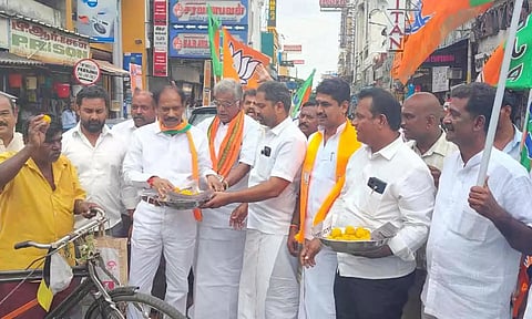 காந்திவீதி-நேரு வீதி சந்திப்பில் பொதுமக்களுக்கு பா.ஜனதா மாநில தலைவர் சாமிநாதன் இனிப்பு வழங்கிய காட்சி.