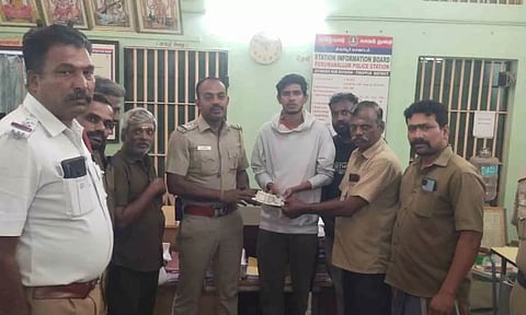 வாலிபரிடம் பணத்தை ஒப்படைத்தக் காட்சி.