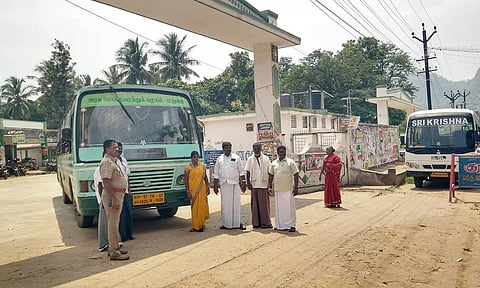 பஸ் நிலையத்திற்கு வெளியில் காத்திருக்கும் பயணிகள்.