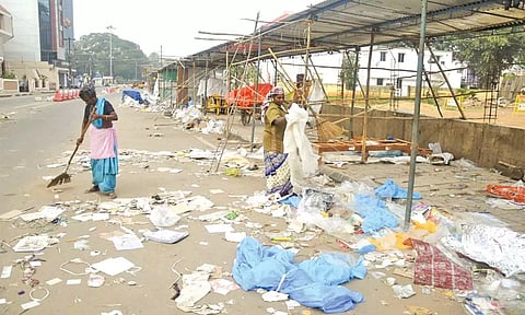 தஞ்சை அண்ணாசாலையில் குவிந்து கிடக்கும் பட்டாசு, பிளாஸ்டிக் கழிவுகளை அகற்றும் பணியில் ஈடுபட்டுள்ள தூய்மை பணியாளர்கள்.