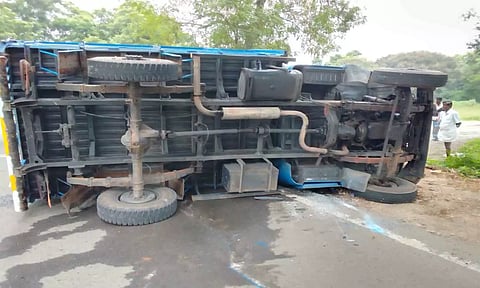 கூலி ஆட்களை ஏற்றி வந்த வேன் கவிழ்ந்து கிடப்பதை படத்தில் காணலாம்.