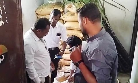 தி.மு.க பிரமுகர் முனிகிருஷ்ணனை அதிகாரிகள், கடையிலிருந்து வெளியேற்றிய காட்சி.