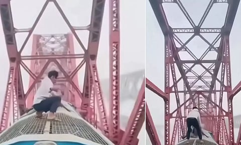 ஓடும் ரெயிலின் மேற்கூரையில் நின்று சாகசம் செய்த வாலிபர்- வீடியோ