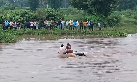 ஆற்றில் அடித்துச்செல்லப்பட்ட காரின் மேற்கூரையில் 2 மணி நேரம் சிக்கித்தவித்த தம்பதி