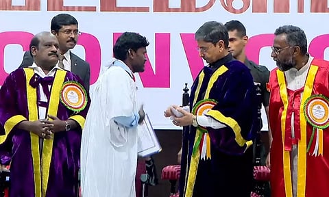 பட்டமளிப்பு விழாவில் கவர்னர் ஆர்.என்.ரவியிடம் ஆராய்ச்சி மாணவர் பிரகாஷ் மனு அளித்த காட்சி.