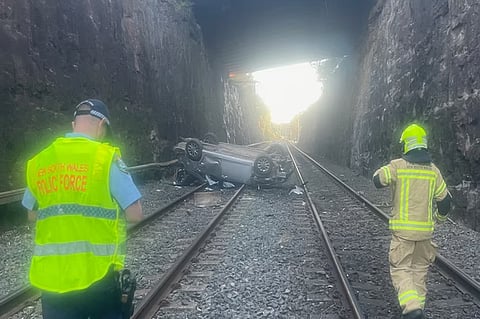 Car crashes onto train tracks,