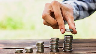 Coins on scale stack on table, symbolic image for fixed deposit