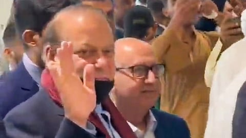 Former Prime Minister of Pakistan Nawas Sharif greets supporters at Islamabad airport.