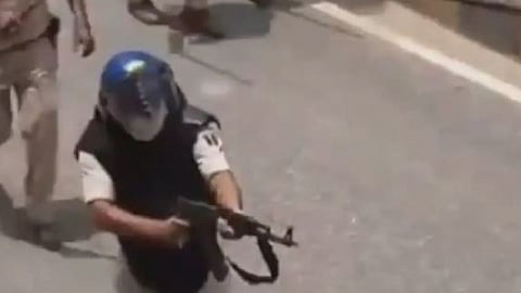 Visuals of a police officer firing an AK-47 at protesters in Bihar.
