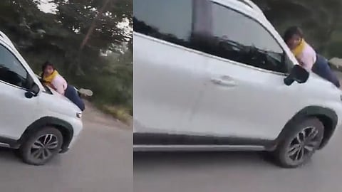 Husband and lover in car; wife lies on the bonnet of the moving vehicle