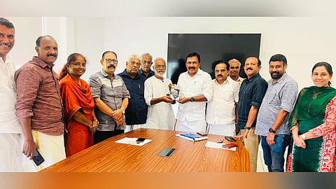MLA Shibu Thekkumpuram receives a book from Dr. Jacob Ittoop, marking the commencement of the book collection drive for the Open Library.