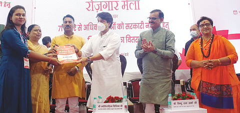 Union Minister for Civil Aviation Jyotiraditya Scindia distributes appointment letters to a beneficiary during a Rozgar Mela, at Samanvay Bhawan in Bhopal on Thursday.
