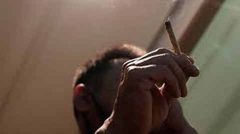 A Japanese tourist smokes cannabis at a Dutch passion shop in Bangkok, Thailand,