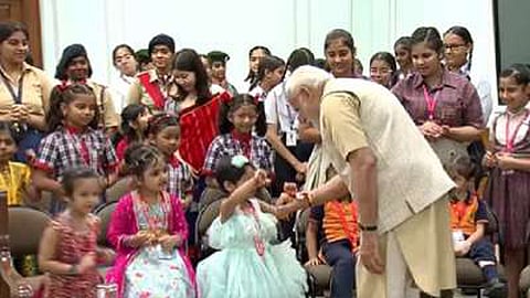 Girls tying rakhi on the wrist of PM Narendra Modi
