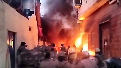 Security personnel at the site after a group of protestors hurled stones and set vehicles on fire after officials demolished a madrasa.