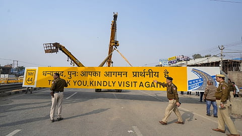 Police remove 'Welcome to Delhi' signboard as security arrangements have been tightened near the Singhu border in view of farmers' 'Delhi Chalo' march.