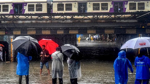 A train passes above the Andheri subway which has been closed due to waterlogging during heavy rainfall, in Mumbai, Thursday, July 25, 2024.