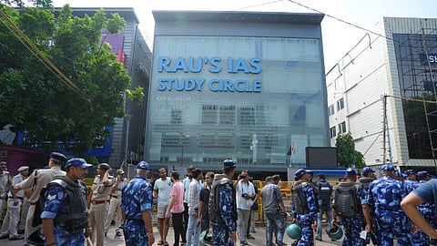 Security personnel stand guard near a UPSC exam coaching centre after three civil services aspirants died when the basement of the coaching centre was flooded by rainwater, in New Delhi, Sunday, July 28, 2024.