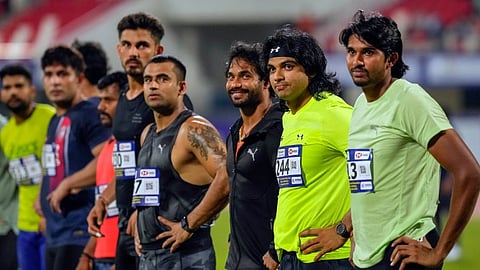 Javelin throwers Neeraj Chopra (2R) and Kishore Kumar Jena (3R) and Manu DP (R) during the line up ahead of the Mens Javelin Throw event of the 27th National Federation Senior Athletics Competition, in Bhubaneswar, Wednesday, May 15, 2024.