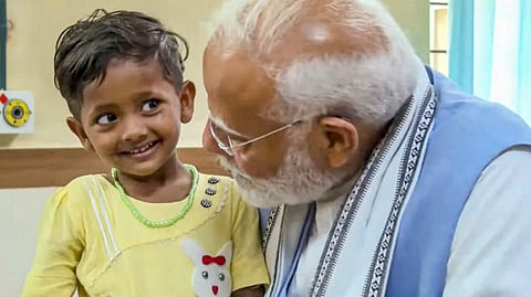 Prime Minister Narendra Modi interacts with a child affected by the recent landslide, at AWS Hospital in Wayanad.