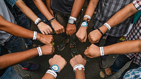 Junior doctors with 'We Want Justice' rakhis on their wrists take part in a sit-in protest against the alleged rape and murder of a woman trainee doctor of R. G. Kar Medical College and Hospital, in Kolkata, Monday, Aug. 19, 2024.