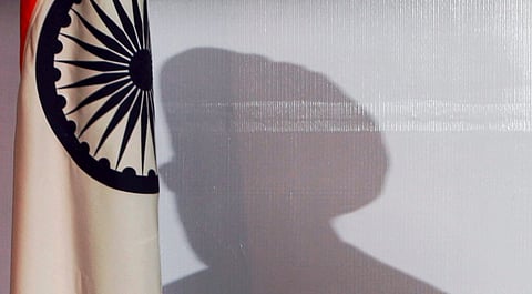 In this Jan. 3, 2014 file image, the shadow of Prime Minister Manmohan Singh in the background during a press conference in New Delhi.