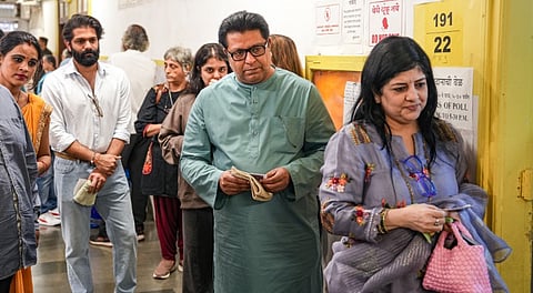 Maharashtra Navnirman Sena (MNS) chief Raj Thackeray with party leader and his son Amit Thackeray and other family members, waits in a queue before casting a vote in the Brihanmumbai Municipal Corporation (BMC) polls, in Mumbai, Thursday, Jan. 15, 2026.