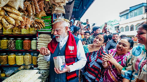 Prime Minister Narendra Modi tries 'jhalmuri', street snack made of puffed rice, on the sidelines of public meetings ahead of the West Bengal Assembly elections, in Jhargram.