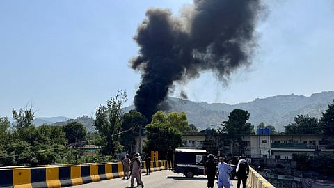 People and police gather nearby as smoke billows from the site where an Mi-17 helicopter of Pakistan Army Aviation crashed near Muzaffarabad, Pakistan Occupied Kashmir, June 10, 2026.