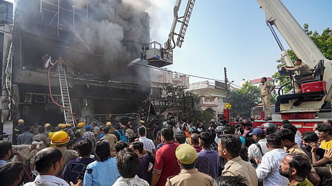 Fire personnel conduct a dousing operation after fire broke out at a commercial building in Aliganj, Lucknow, Uttar Pradesh, Monday, June 22, 2026.