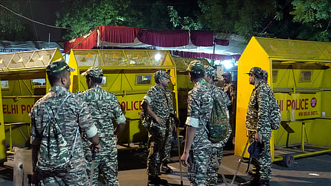 Security personnel stand guard during a protest organised by Cockroach Janata Party (CJP) demanding Pradhan's resignation over alleged irregularities in the NEET examination, at the Jantar Mantar, in New Delhi, early Sunday, July 19, 2026.