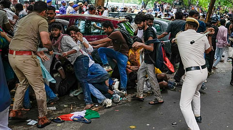 Police personnel stop Cockroach Janata Party (CJP) supporters as they raise slogans during a protest march, at Sansad Marg, in New Delhi, Monday, July 20, 2026.