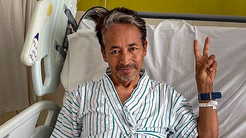 Climate activist Sonam Wangchuk in hospital shows victory sign to media after Education Minister Dharmendra Pradhan resigned from the Union Cabinet, in Gurugram, Saturday, July 25, 2026.