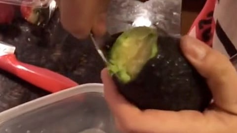 La mujer sólo corta una parte del aguacate para conservarlo por más días (Fotograma de video: Margaret Drisi )