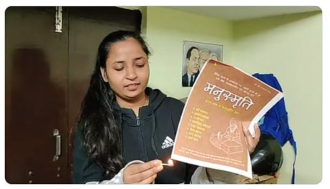 Meena Kotwal, the founder of "The Mooknayak" burning the Manusmriti / Photo Credit: @KotwalMeena