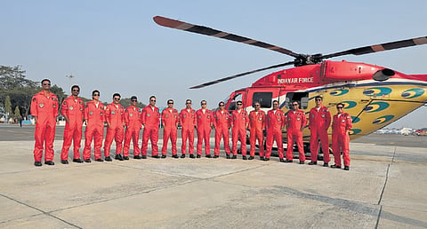 The Sarang Helicopter Display Team of the IAF stands next to the HAL Dhruv at the Begumpet Airport in Hyderabad.