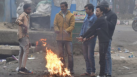 People around a bonfire to protect themselves from winter on a coldest and foggy morning in New Delhi,