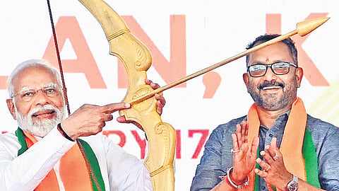 Modi displaying the bow and arrow made of teakwood presented to him by BJP state president K Surendran at the meeting of BJP’s grassroots-level functionaries.
in Kochi on Wednesday | Express