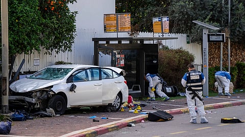 Israeli security forces work at the site of a Palestinian car-ramming and stabbing attack at a bus stop, in Ra'anana, Israel, Monday, Jan. 15, 2024. Israeli police say a car-ramming and stabbing attack by Palestinians killed a woman and wounded at least 12 others north of Tel Aviv.